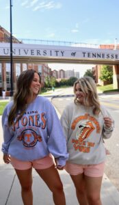 two women standing infromt of a bridge with boutique clothing on 
