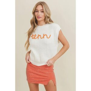 woman in an orange skirt and white sweater with "Tenn" in orange